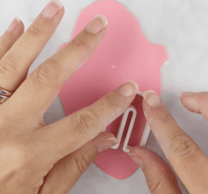 cutting polymer clay earrings with arched clay cutter using pink clay